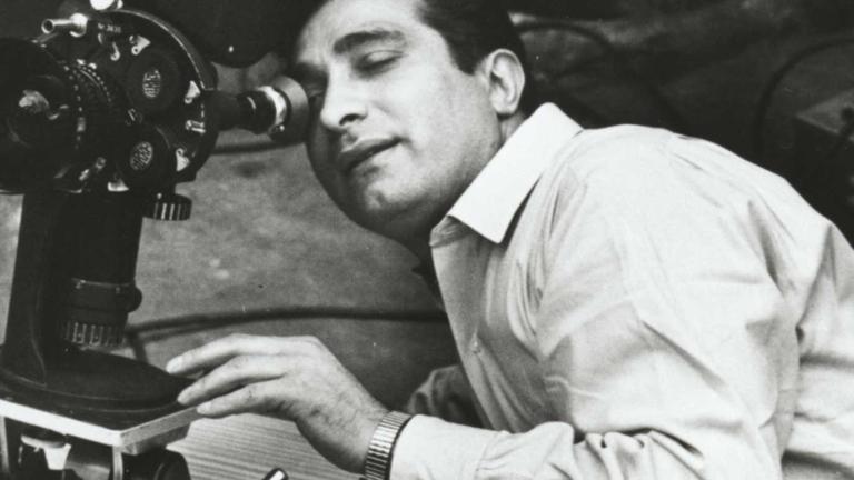 A man leaning over and looking into a movie camera