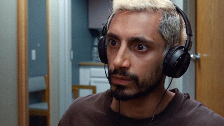 Close up of actor Riz Ahmed in a scene from Sound of Metal, wearing headphones