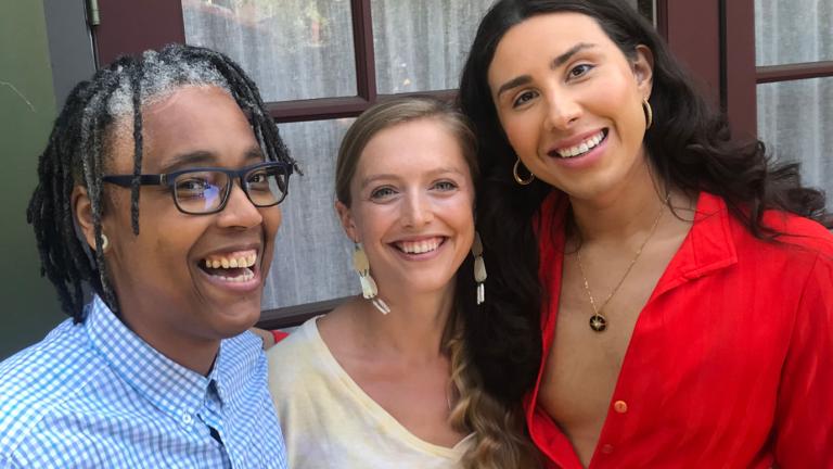 Head and shoulders shot of 3 people standing side by side and smiling at the camera.