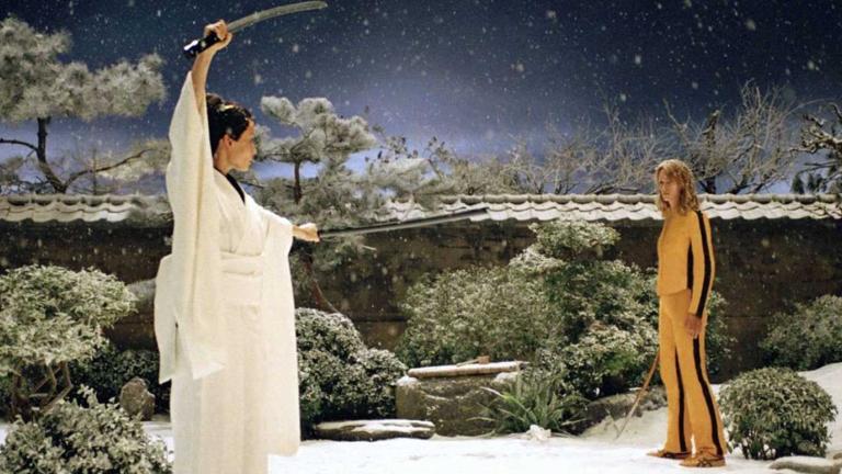 Two women, one dressed in white and the other in yellow, facing off against each other in a samurai sword battle, in a scene from Kill Bill: Volume 1
