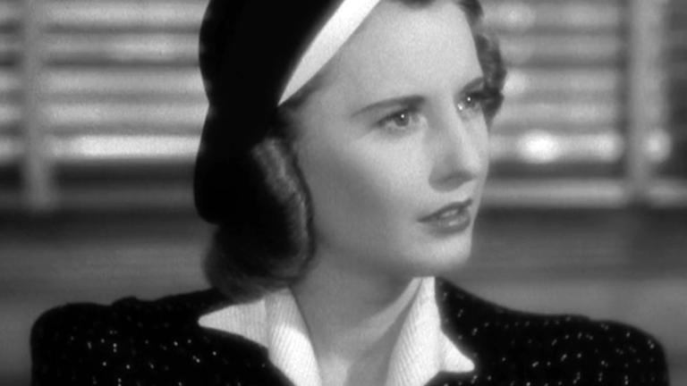 Close up of actor Barbara Stanwyck, c1940 with her head turned slightly to her left and with a concerned look on her face.