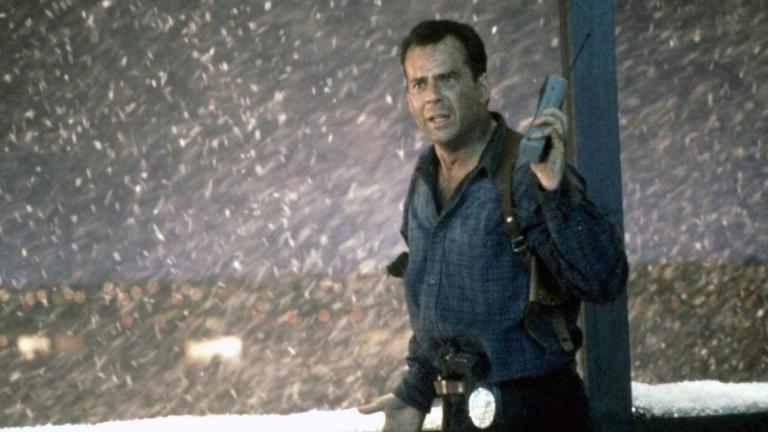 Actor Bruce Willis standing out in the snow at night time in a scene from Die Hard 2.