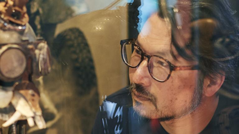 Man wearing glasses observing an exhibition item