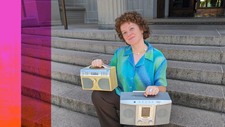 A woman sits on concrete steps holding two portable radios, one on each knee