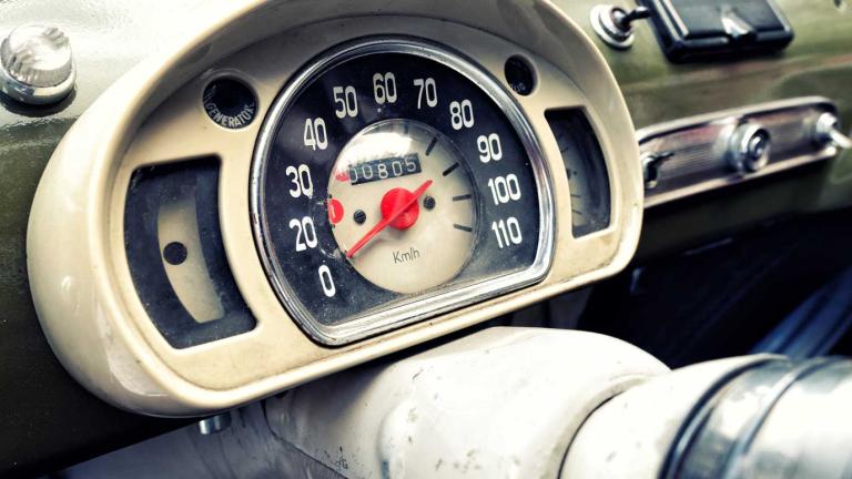 A dashboard of a vintage car showing the speedometer.