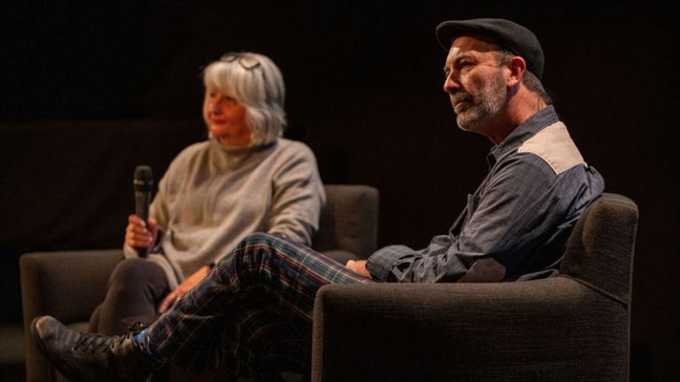 Two people sitting on a stage