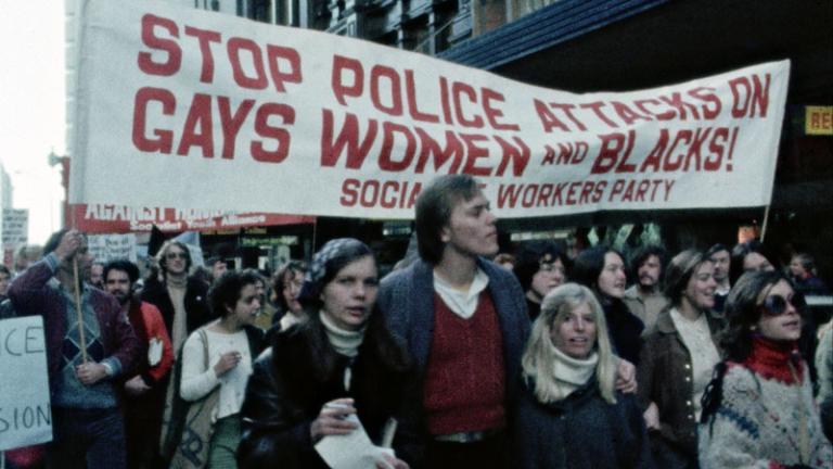 A group of people holding banners and marching in protest.