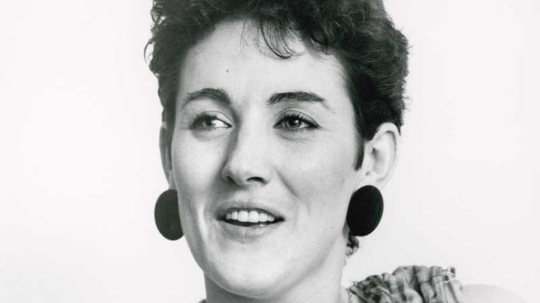 Head and shoulders shot of singer Grace Knight looking slightly away from camera and holding a coffee cup in both hands.