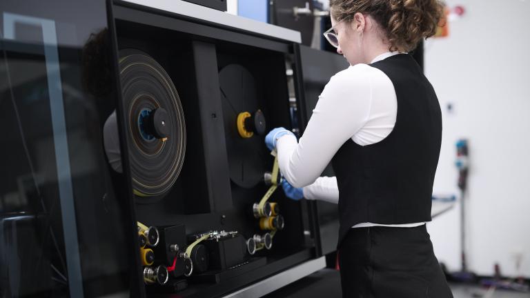 Woman working at a film digitisation machine