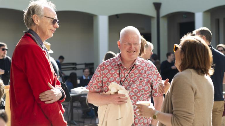 A group of three chatting in a courtyard