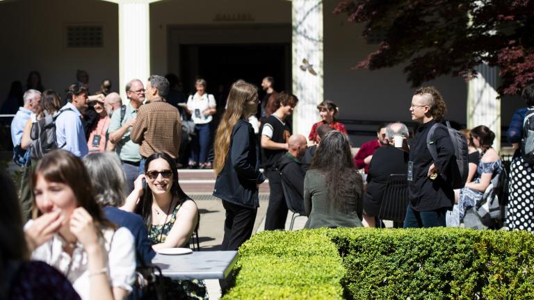 Conference attendees eating and chatting in a courtyard