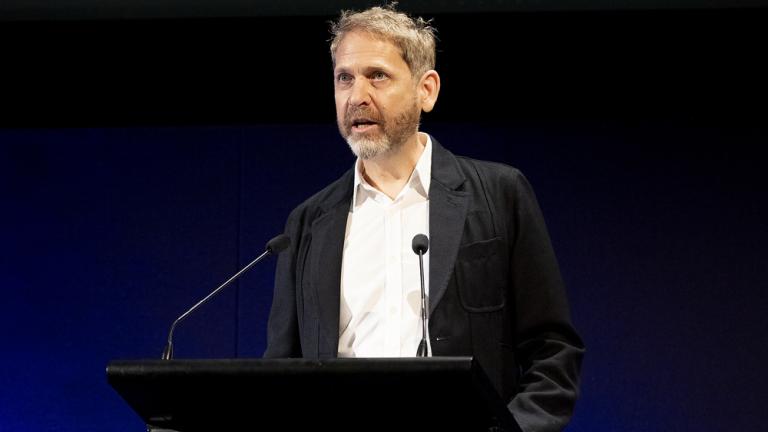 Patrick McIntyre speaking on a podium