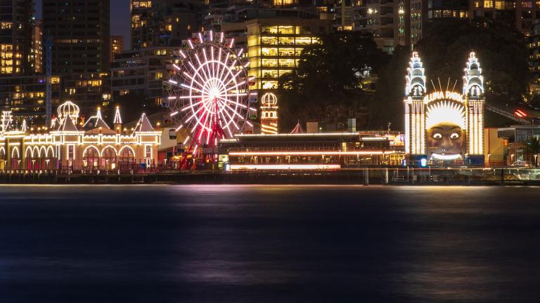 Luna Park in Sydney lit up at night, pictured from across Sydney Harbour