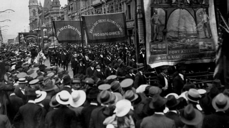 A crowd lines the street watching a trade union procession in Adelaide in 1918.
