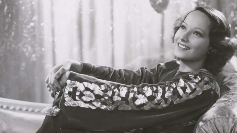 Merle Oberon reclining on a chaise longue