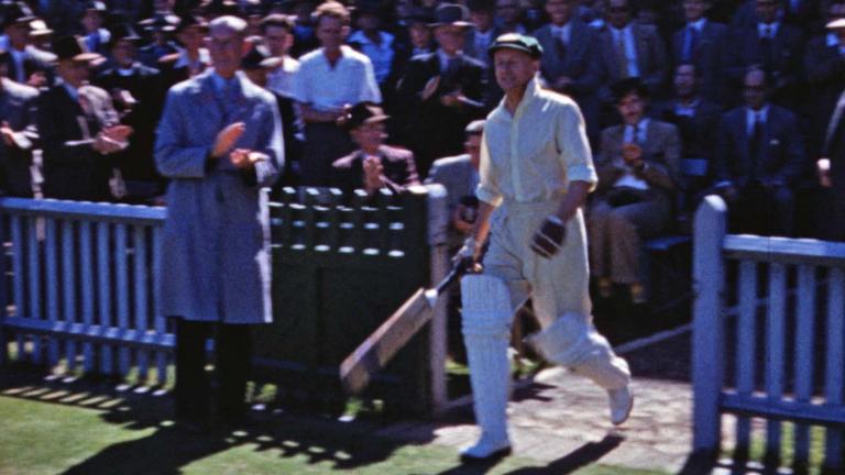 Cricketer Sir Donald Bradman walks onto the Sydney Cricket Ground ready to bat.