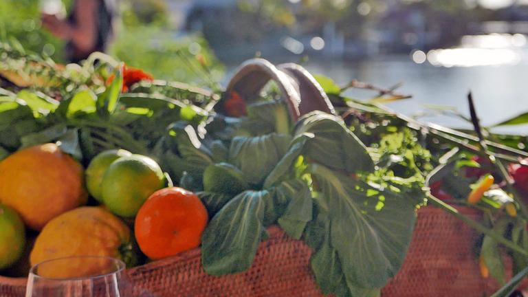 A close up of a basket containing fresh fruits and vegetables
