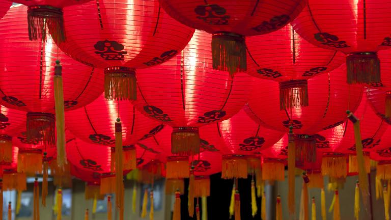 A big collection of red Chinese hanging lanterns with yellow tassles  