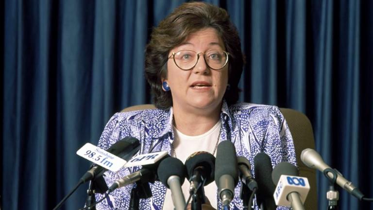 Politician Dr Carmen Lawrence talking at a press conference. She has many microphones in front of her.