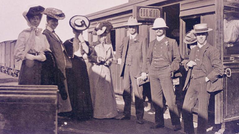 The Corrick family standing in front of a train. c.1906