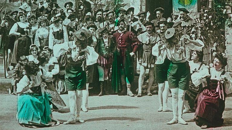 screenshot from an early tinted film showing a group of dancers