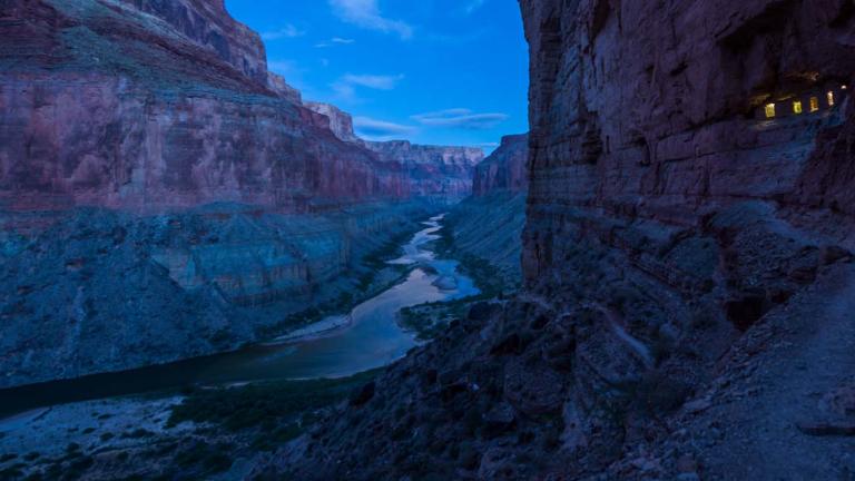 A river passing through a spectacular Grand Canyon landscape during the dark blue of night