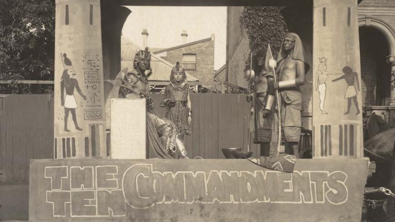 Four actors in costume pose on a horse-drawn trailer promoting The Ten Commandments in 1925