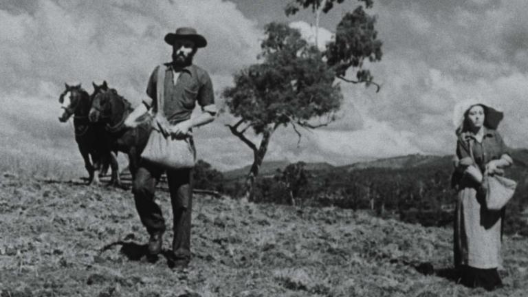 A man and woman sow seeds on an outback farm in a still from the 1949 film Sons of Matthew
