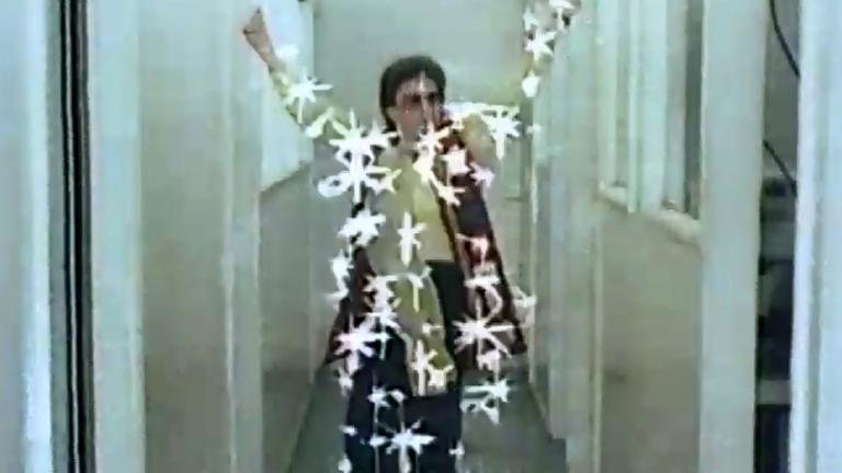 Frame capture of a woman in a hallway with superimposed starbursts across her body