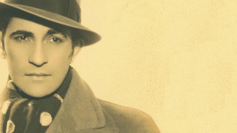 Portrait of Con Colleano in hat and coat looking away from camera