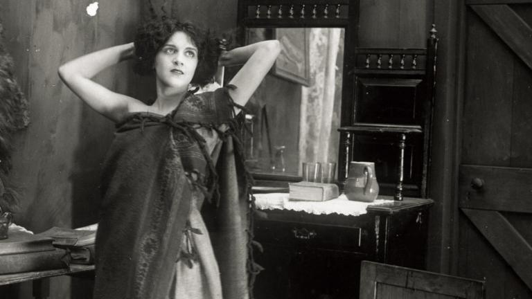 Still image from Moth of Moonbi showing Doris Ashwin standing with hands behind her head