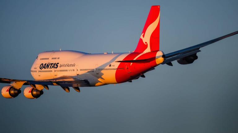 A passenger aircraft Boeing 747-400 in Qantas colour scheme taking off from Kingsford Smith airport