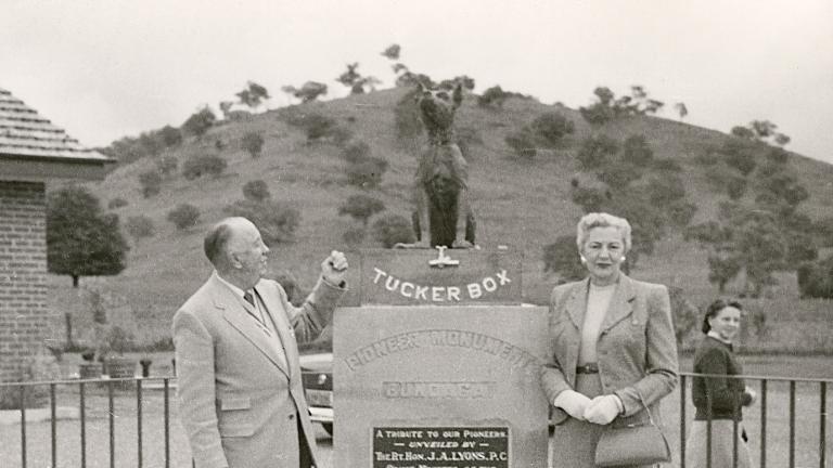Jack O'Hagan standing beside a statue of the dog on the tuckerbox in Gundagai.