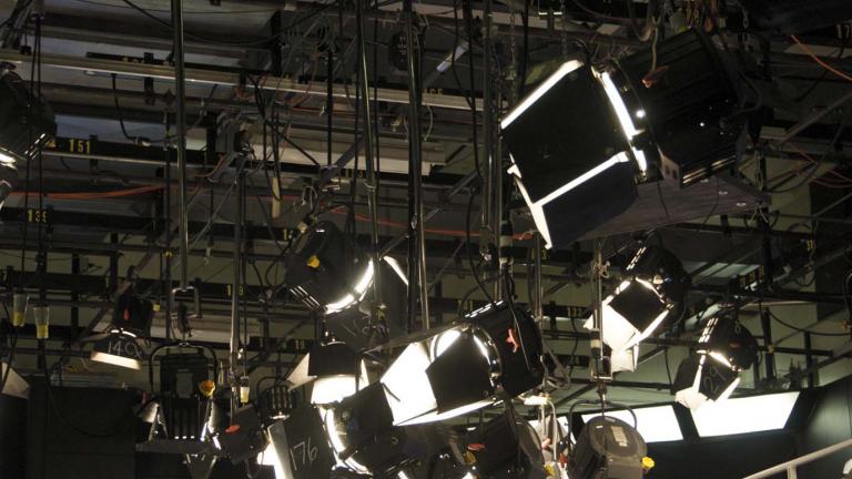 An array of studio lights suspended from the ceiling of a TV studio