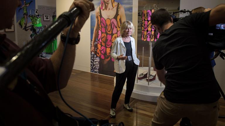 Margaret Pomeranz at the Starstruck exhibition. She's posing with the Priscilla thong dress for a TV crew.