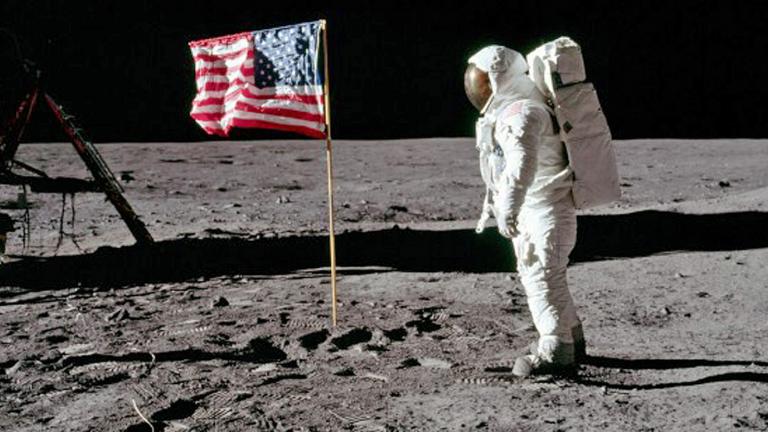 Astronaut on the moon standing near the American flag