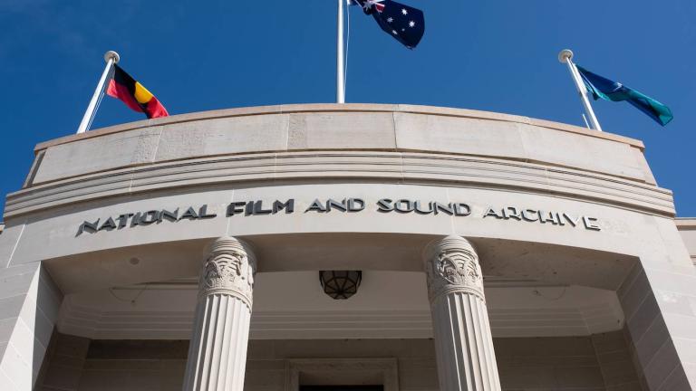 A close-up of the NFSA building in Canberra with the Aboriginal, Australian and Torres Strait Islander flags flying on top of the building