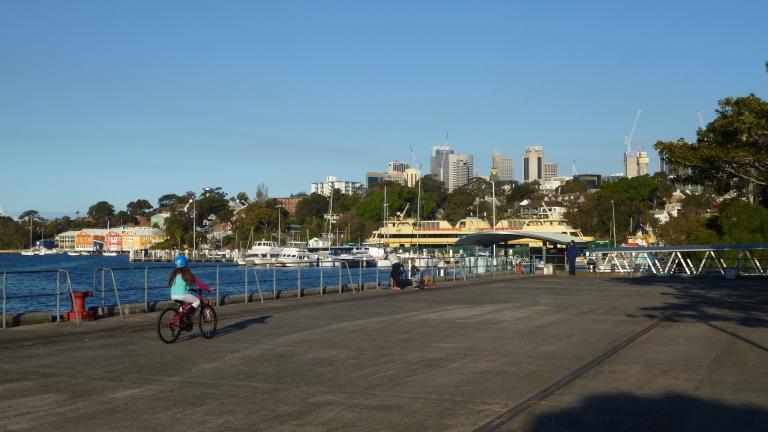 Child riding a bike along a warf on Sydney harbour Child riding a bike along a warf on Sydney harbour