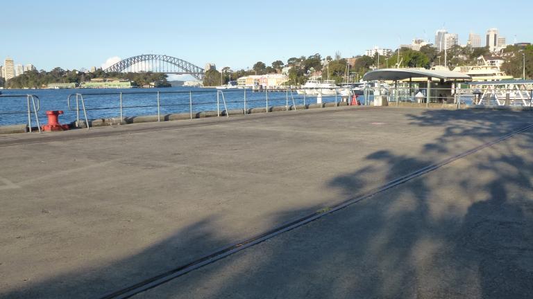 View of warf on Sydney Harbour with an old rail line in the foreground View of warf on Sydney Harbour with an old rail line in the foreground