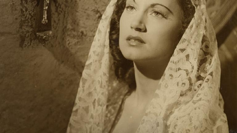 Betty Bryant wearing a shawl next to a crucifix in a scene from Forty Thousand Horsemen.
