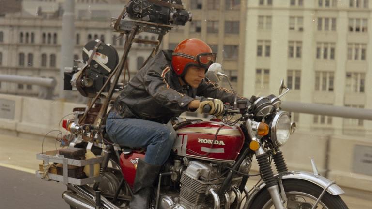 A man rides a motorcycle with a camera mounted on the back. A man rides a motorcycle with a camera mounted on the back.