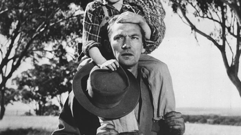 Peter Finch with Dana Wilson on his shoulders holding his hat on a country road Peter Finch with Dana Wilson on his shoulders holding his hat on a country road