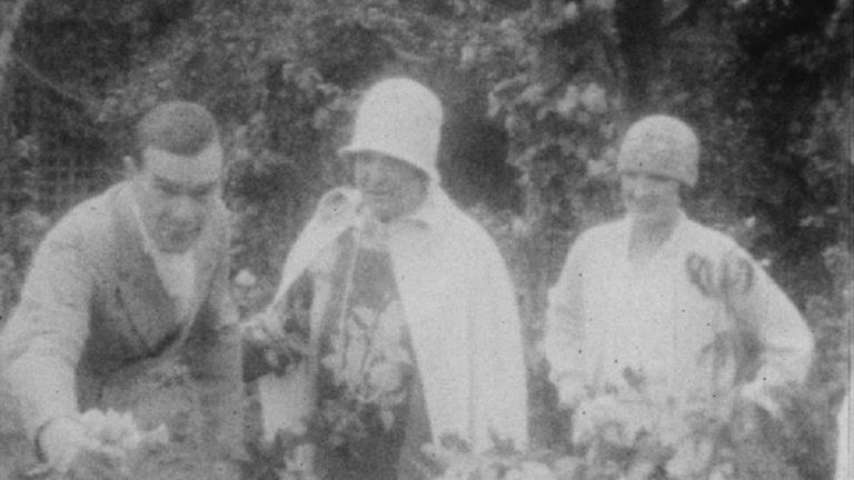 Frame capture of Melba with an unknown couple in the garden