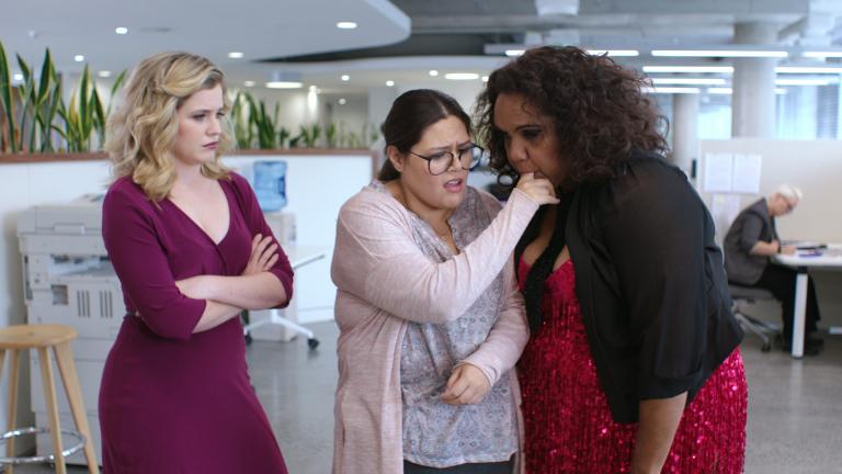 Three women. One has stuck her finger in another's mouth.