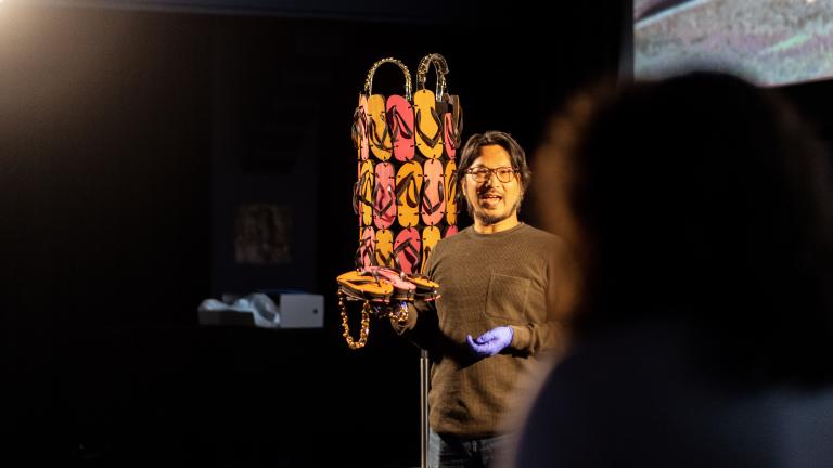 NFSA Conservator Shingo Ishikawa standing in front of the thong dress from the film The Adventures of Priscilla, Queen of the Desert