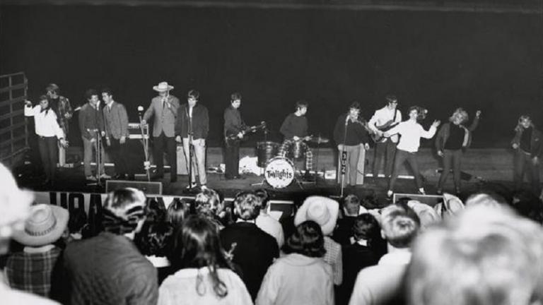 Pop band on stage performing in front of a large crowd. Pop band on stage performing in front of a large crowd.