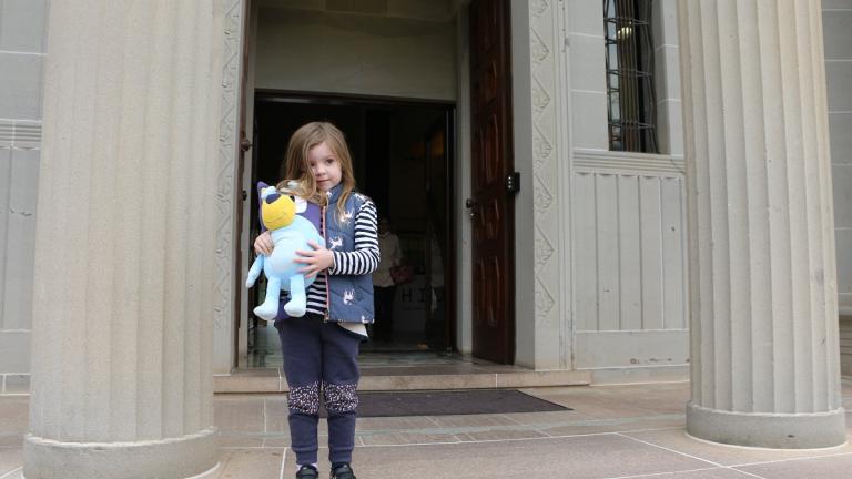 A young Bluey fan at the NFSA A young Bluey fan standing at the NFSA entrance, holding a plush doll of Bluey