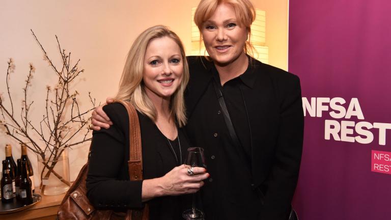 Actors Simone Buchanan and Deborah Lee-Furness pictured from the waist up posing for the camera in front of an 'NFSA Restores' banner.