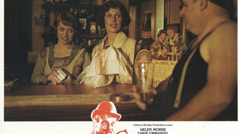 Caddie lobby card with Jacki Weaver as Josie and Helen Morse as Caddie behind the bar in a pub talking to a rough looking customer.