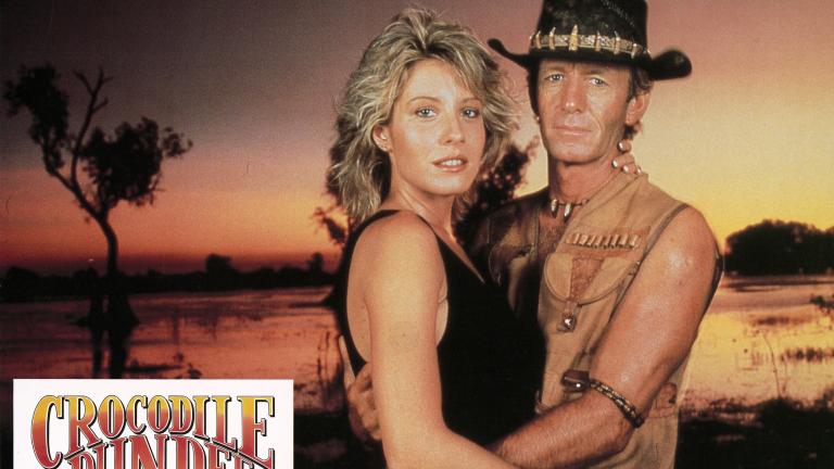 Love in the outback Lobby card depicting Linda Kozlowski as Sue Charlton and Paul Hogan's Mick 'Crocodile’ Dundee looking at the camera